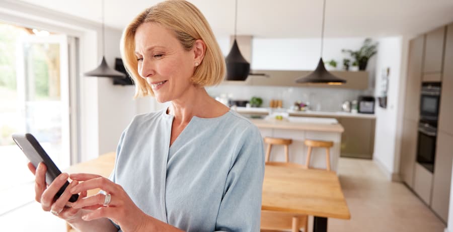 Homeowner using a mobile device in a modern home